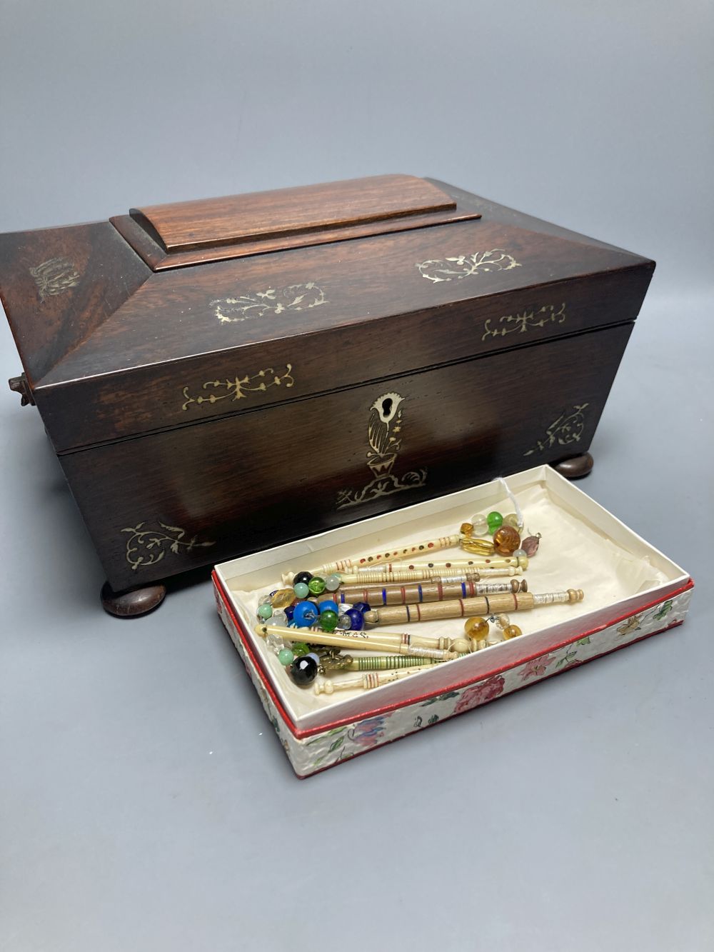 A Victorian mother of pearl-inlaid rosewood sewing box, containing various accessories, lace bobbins, etc.